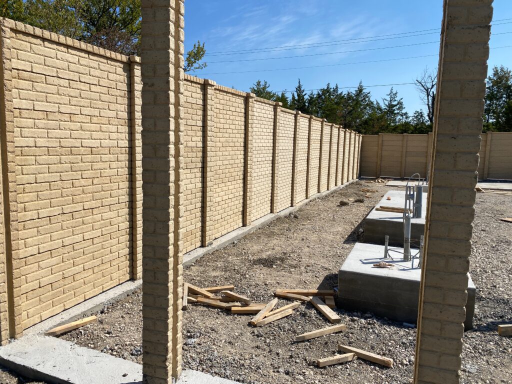 Tan brick-textured precast panel equipment enclosure built by Dayd Masonry in Fort Worth, TX