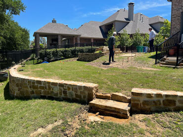 Low-terrain backyard retaining wall masonry by Dayd Masonry in Dallas