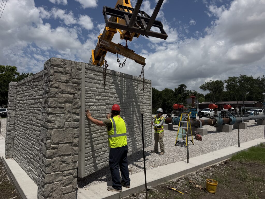 Worker guiding stacked precast concrete panels being lifted into place by Dayd Masonry in the Dallas-Fort Worth, TX area